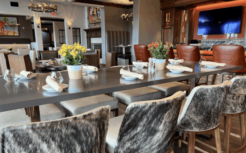 Dining setup with fur-backed chairs and daisy centerpieces.